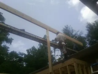 Carpenter setting a ridge beam over a new addition frame — Ice Dam Removal by Roofing Brothers in Yaphank