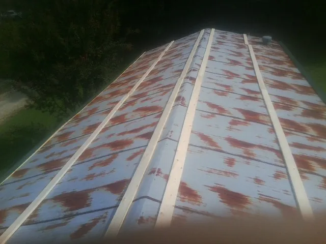 Rusted metal roof panels with new wood purlins before replacement — Storm Damage Roof Repair in Yaphank by Roofing Brothers