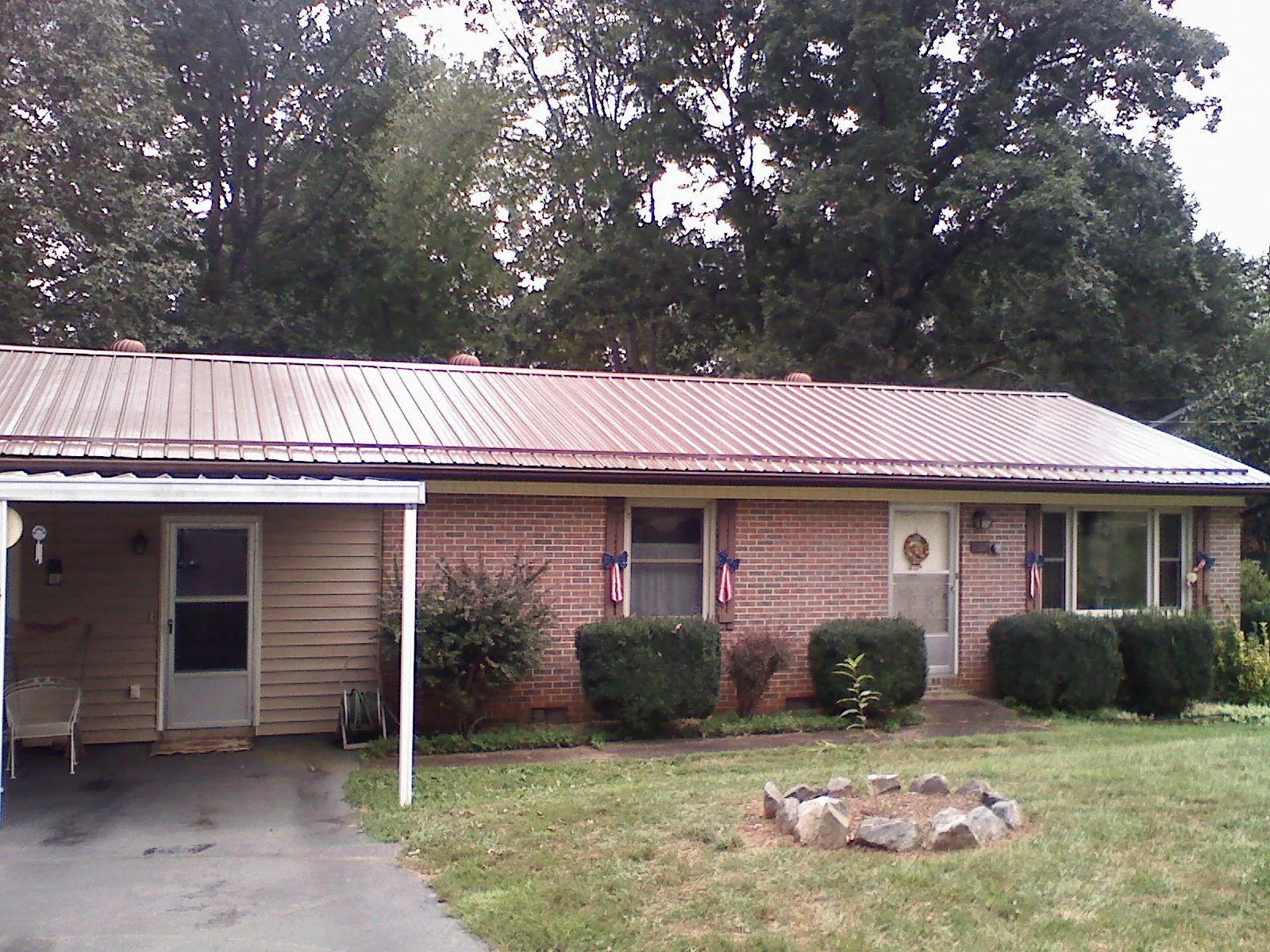 Bronze metal roof and carport on a brick ranch home — Roof Repair work by our crew in Yaphank