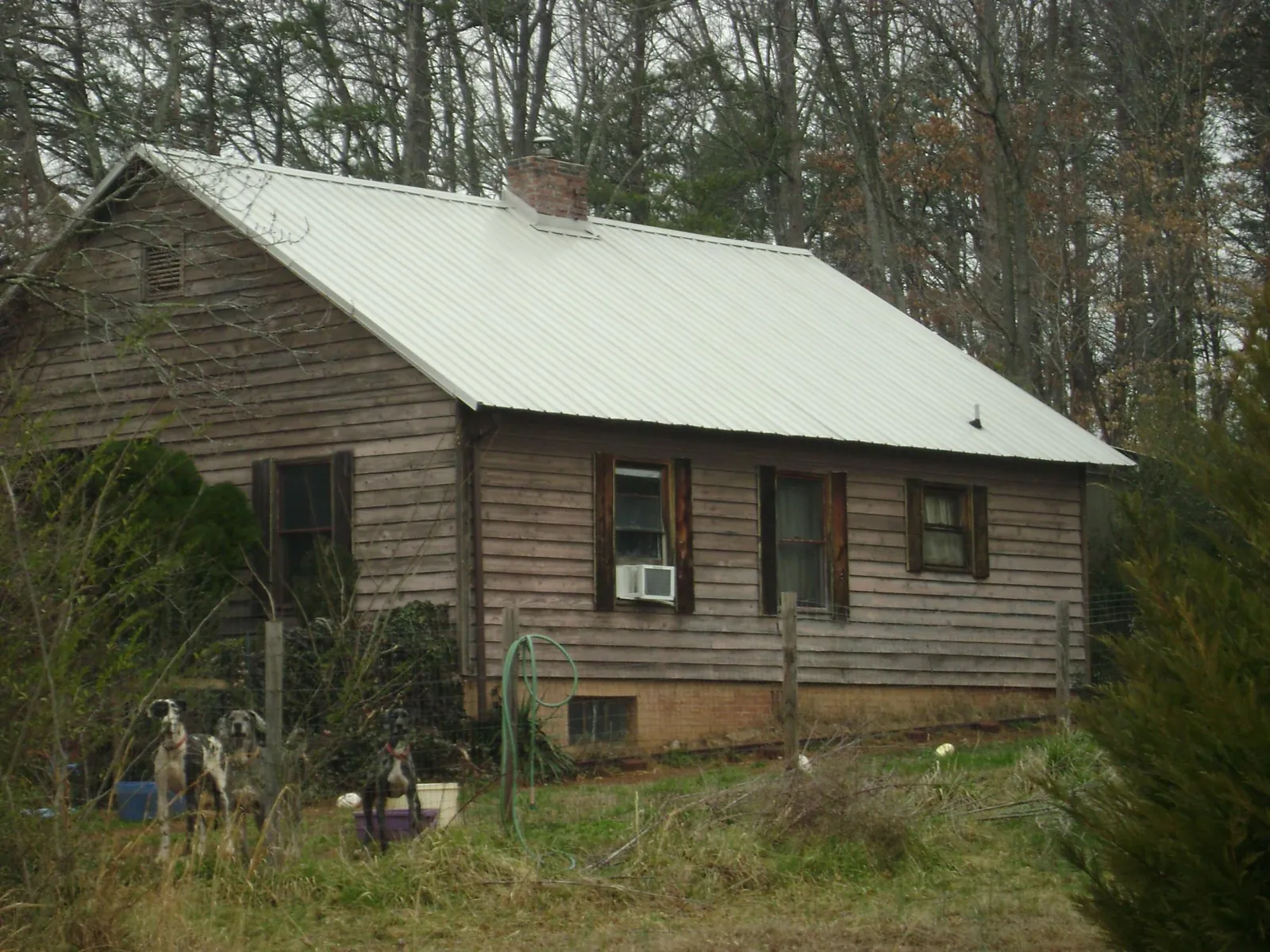 White metal roof on an old wood sided farmhouse, from a Metal Roof Installation job in Yaphank